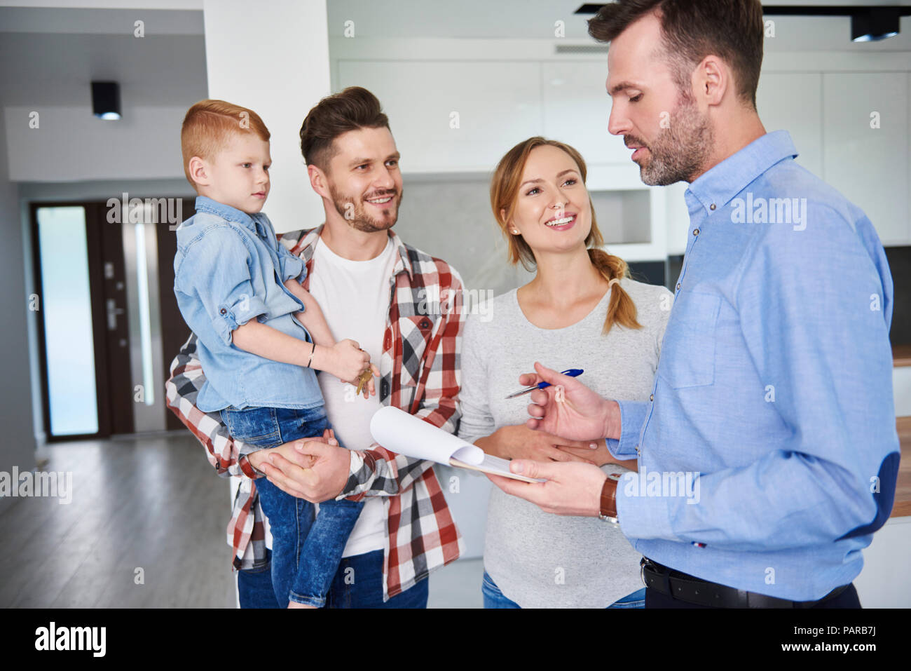 Y la familia real estate agent hablando en nuevo apartamento Foto de stock