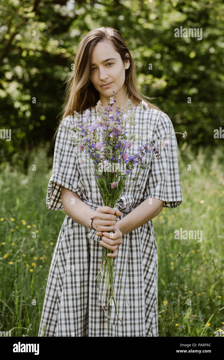 Italia, Veneto, joven sosteniendo ramo de flores silvestres Foto de stock