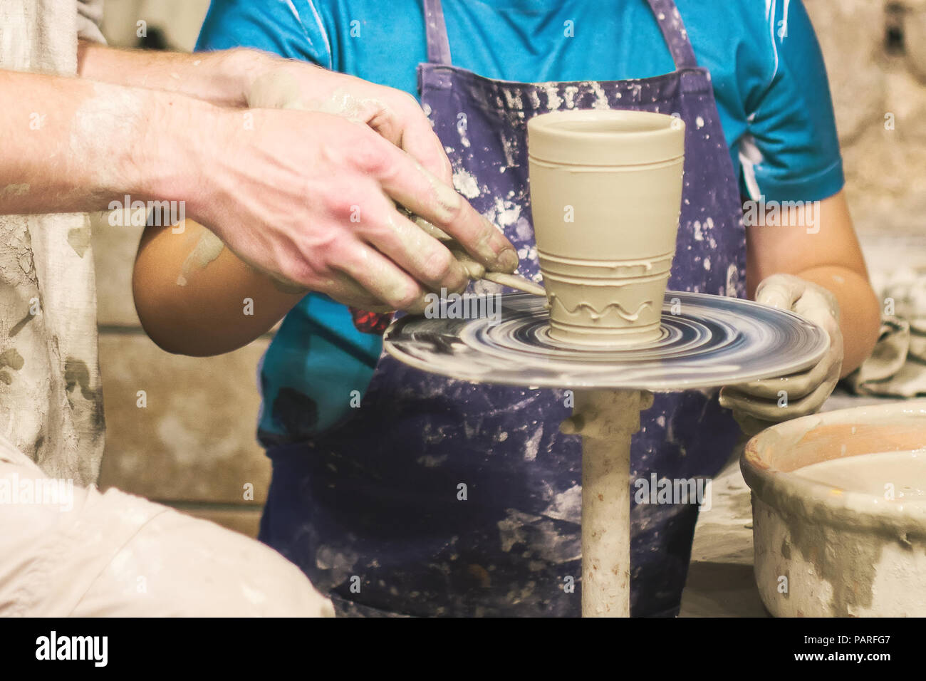 Raw de una olla de barro en manos del alfarero. Taller en el taller de cerámica artesanal Foto de stock