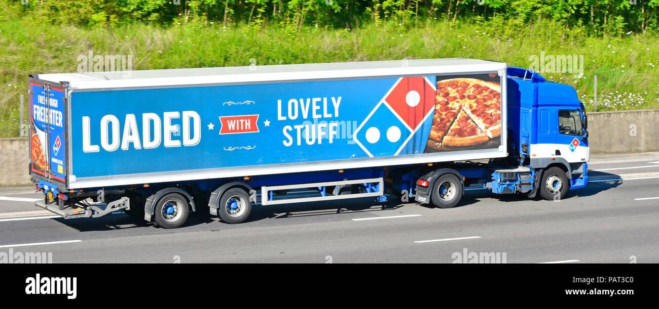Vista lateral largo Domino's Pizza negocio global de la cadena de suministro de alimentos entrega vhg camión camión con logotipos y publicidad del producto en el lado del remolque autovía del Reino Unido Foto de stock