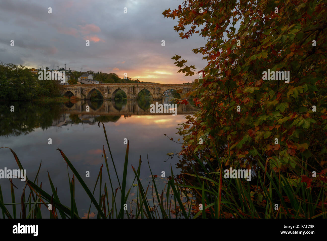 El puente romano sobre el río Miño al atardecer, en Lugo, Galicia Foto de stock