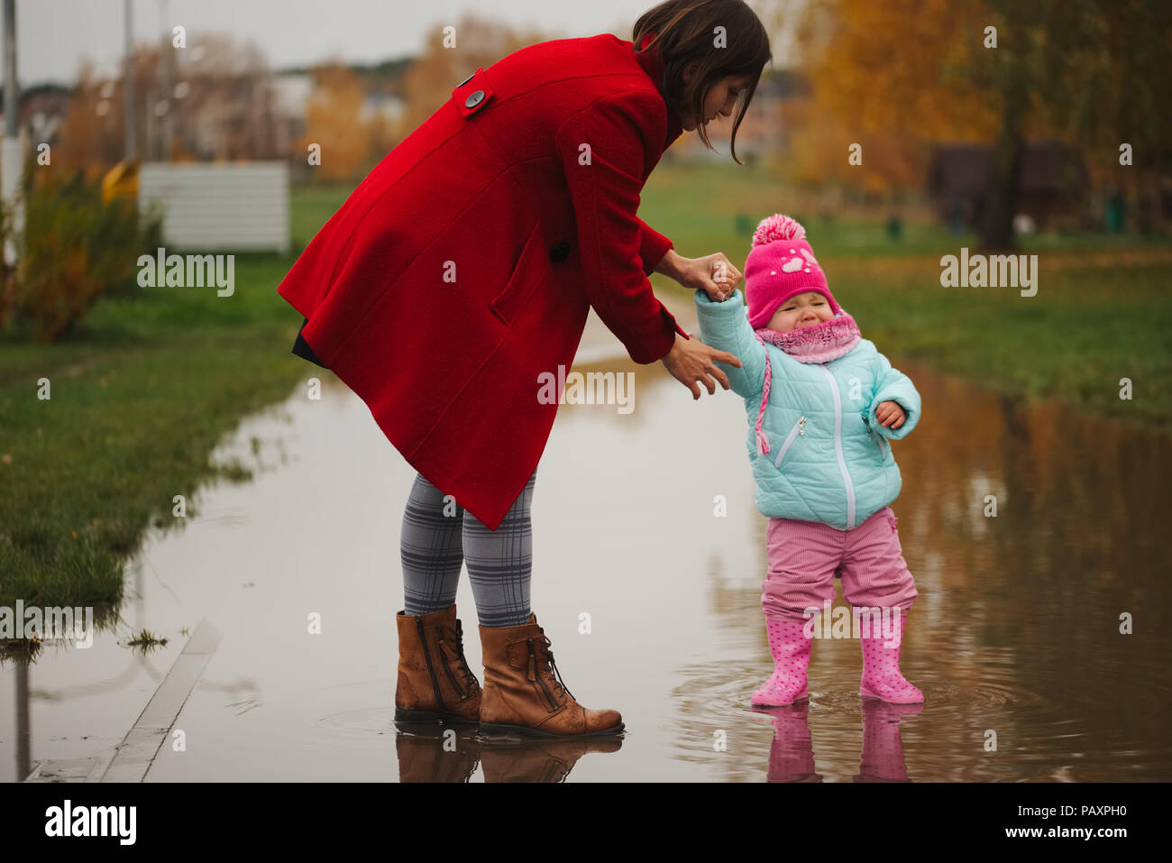 Niña con botas de caucho en charco Fotografía de stock - Alamy