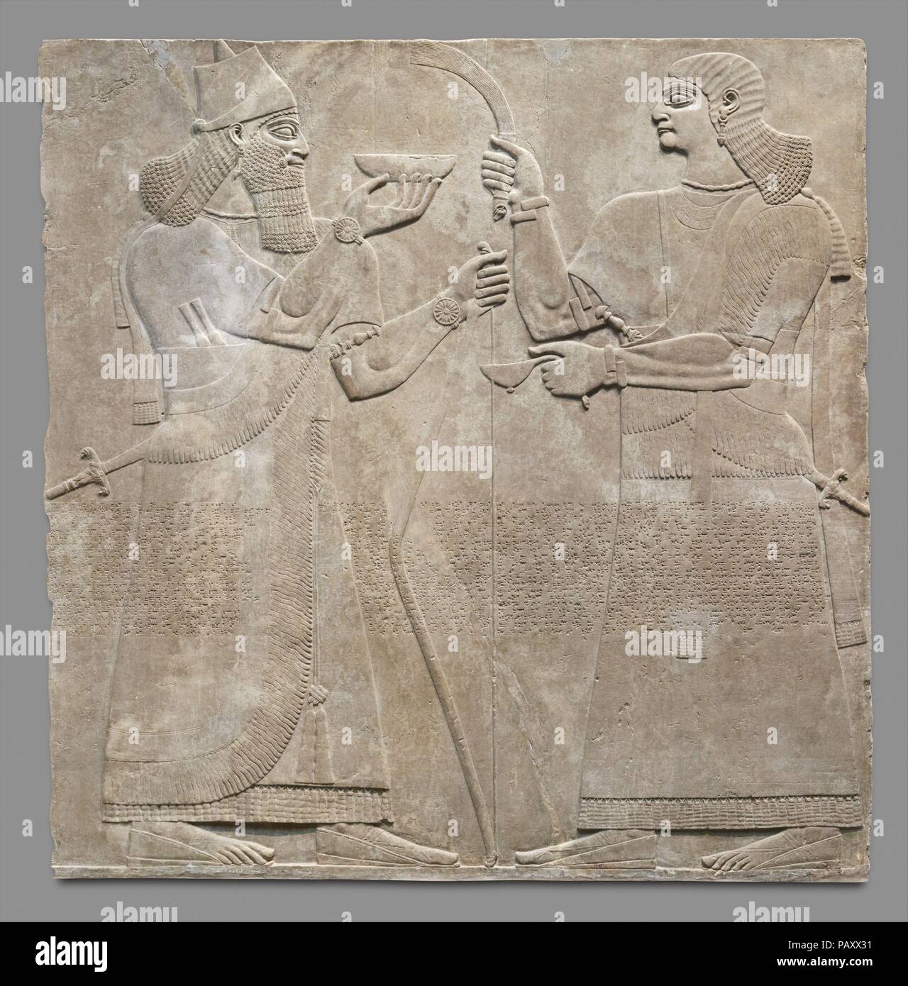 Panel de socorro. Cultura: Asirio. Dimensiones: 92 x 92 1/4" x 4 1/2". (234.3 x 233.7 x 11.4 cm). Fecha: ca. 883-859 B.C.. Este alivio, desde el palacio del rey asirio Ashurnasirpal II (r. ca. 883-859 a.C.), representa a un rey Ashurnasirpal probablemente sí, y un acompañante. Los dos grandes de figuras de tamaño natural están tallados en bajo relieve, y como con otros relieves en el palacio con la imagen del rey, el tallado es particularmente fino y muestra una especial atención al detalle. El grupo se une a un segundo relieve que muestra una nueva operadora, también ante el rey, y un sobrenatural alado p Foto de stock