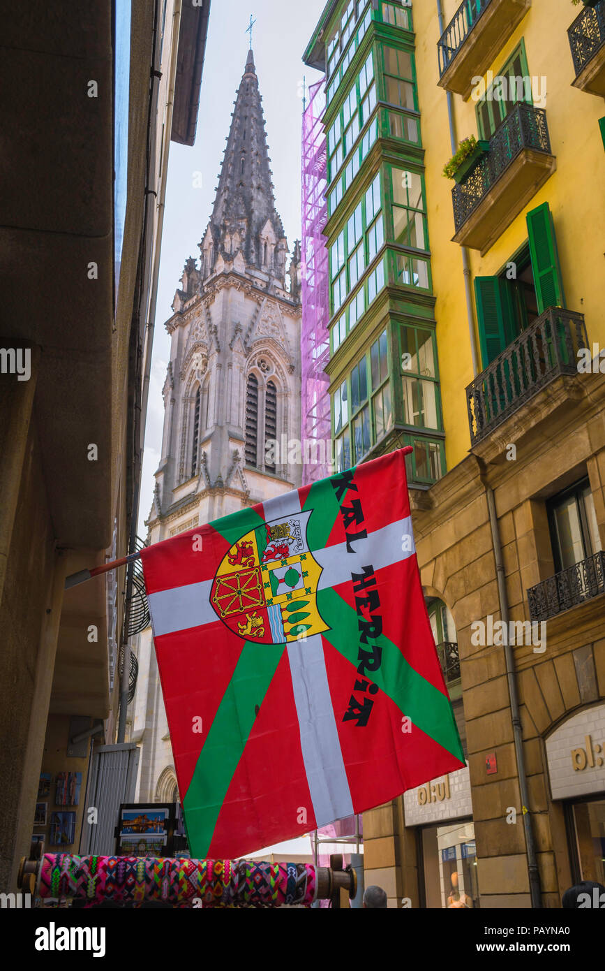 Bilbao street, vista de un Vasco (Euskadi) bandera con un escudo municipal colgando en el centro del Casco Viejo (Old Town) de Bilbao. Foto de stock