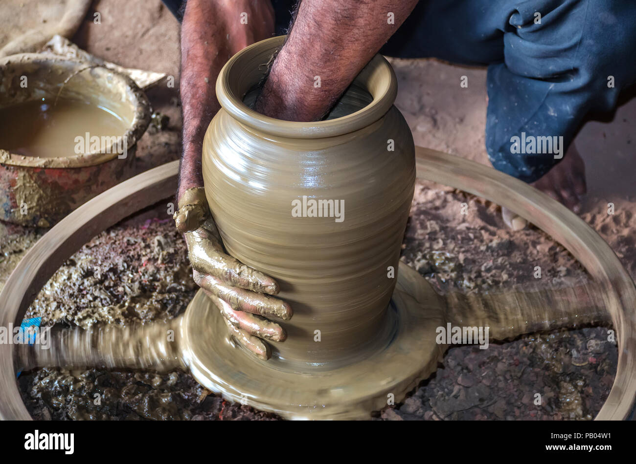 Acercamiento de las manos del alfarero en la olla de agua de arcilla  haciendo alfarería rueda. Las ollas de barro son utilizados desde la  antigüedad y se pueden encontrar en el subcontinente