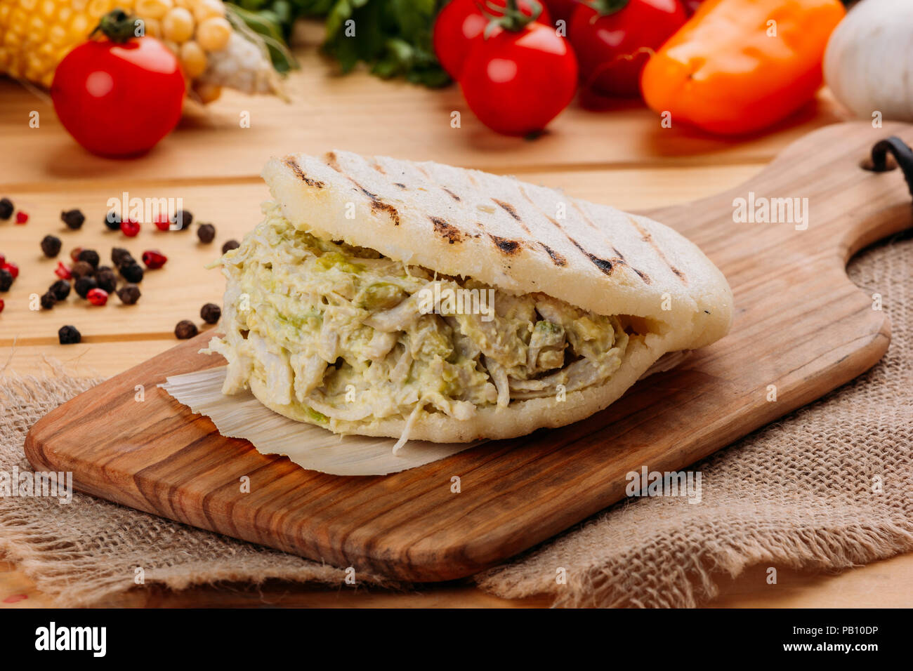 Famosos y deliciosos AREPA venezolana llamada la reina pepeada sobre una placa de cocina Foto de stock