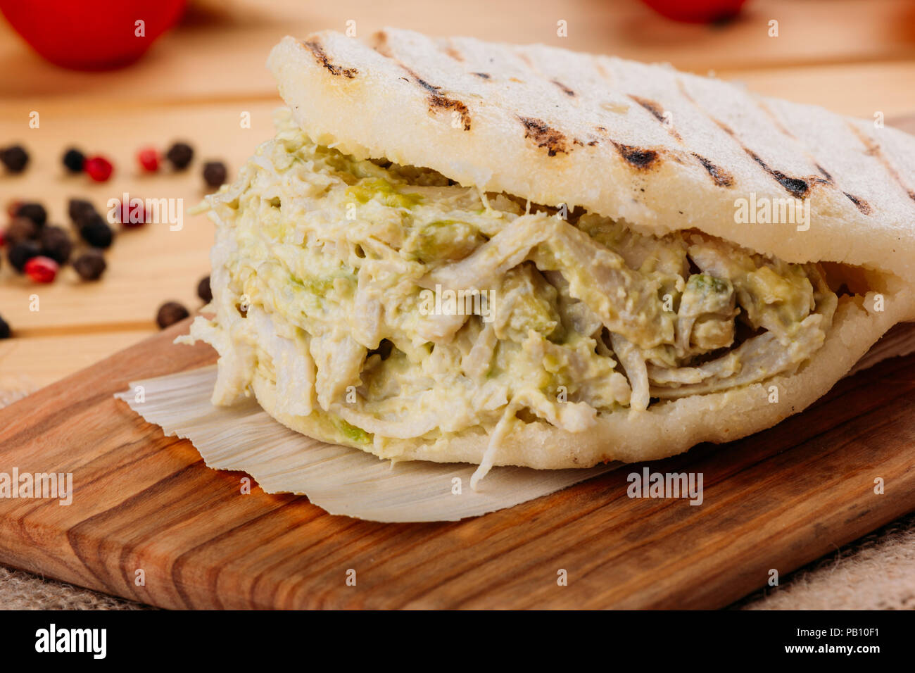 Famosos y deliciosos AREPA venezolana llamada la reina pepeada sobre una placa de cocina Foto de stock