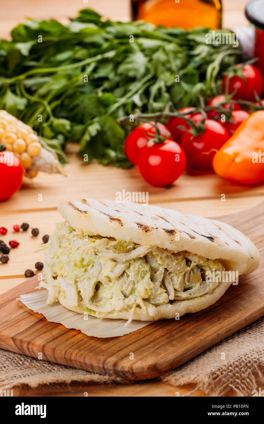 Famosos y deliciosos AREPA venezolana llamada la reina pepeada sobre una placa de cocina Foto de stock