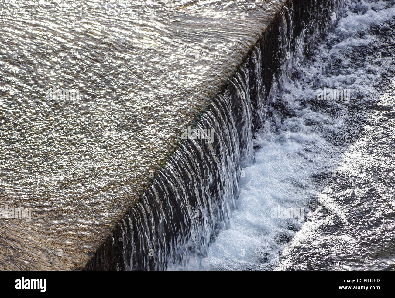 Regula el flujo de agua del canal de riego y que fluye a través del centro de una ciudad. Foto de stock
