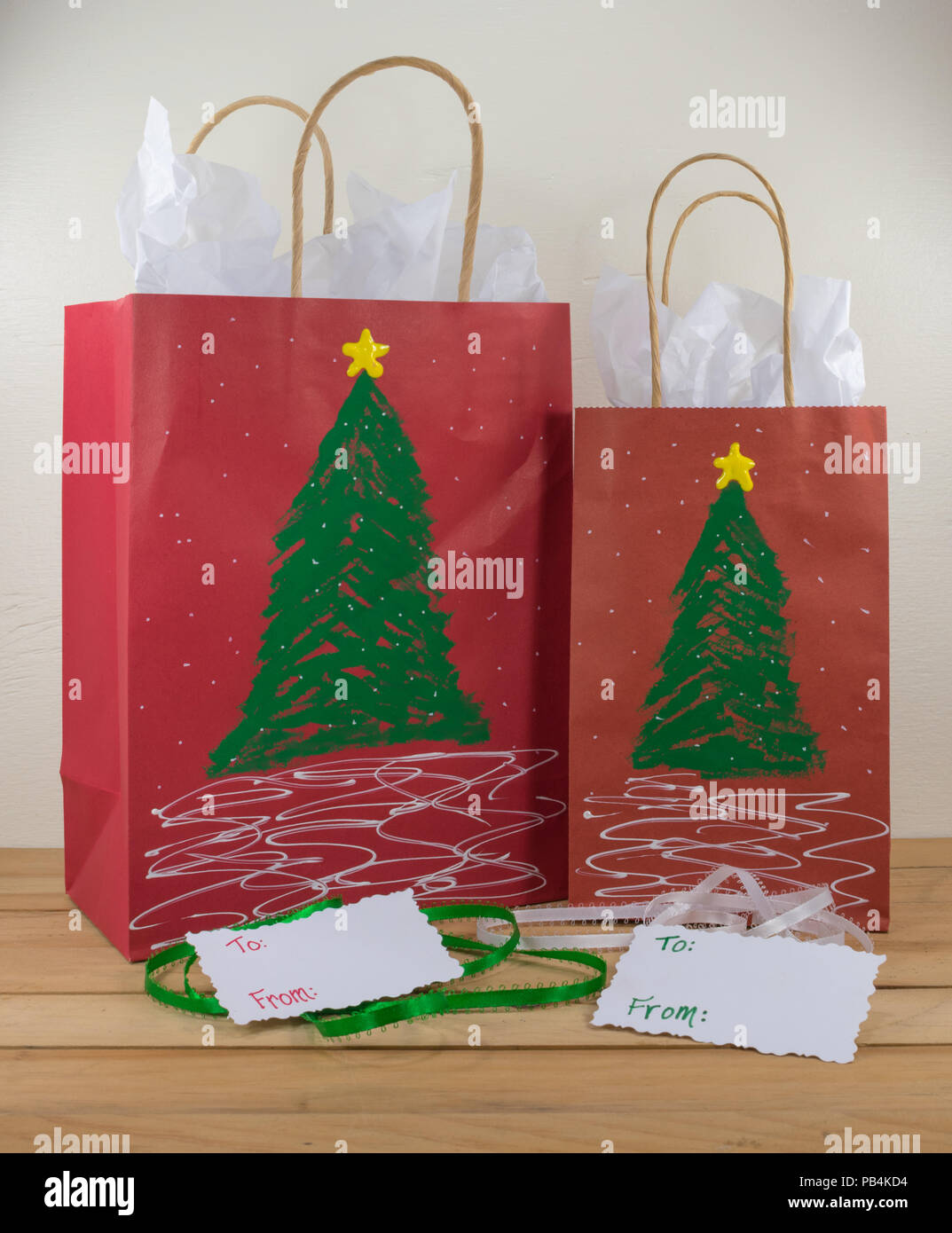 Dos bolsas de regalo de papel rojo decorado para la Navidad y listo para  regalar junto con etiquetas y cinta verde y blanco Fotografía de stock -  Alamy