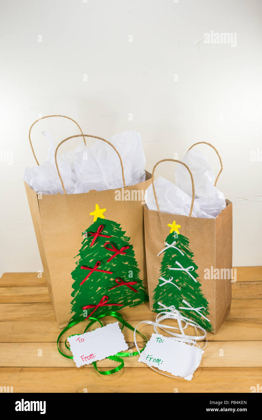 Dos bolsas de regalo de papel rojo decorado para la Navidad y listo para  regalar junto con etiquetas y cinta verde y blanco Fotografía de stock -  Alamy