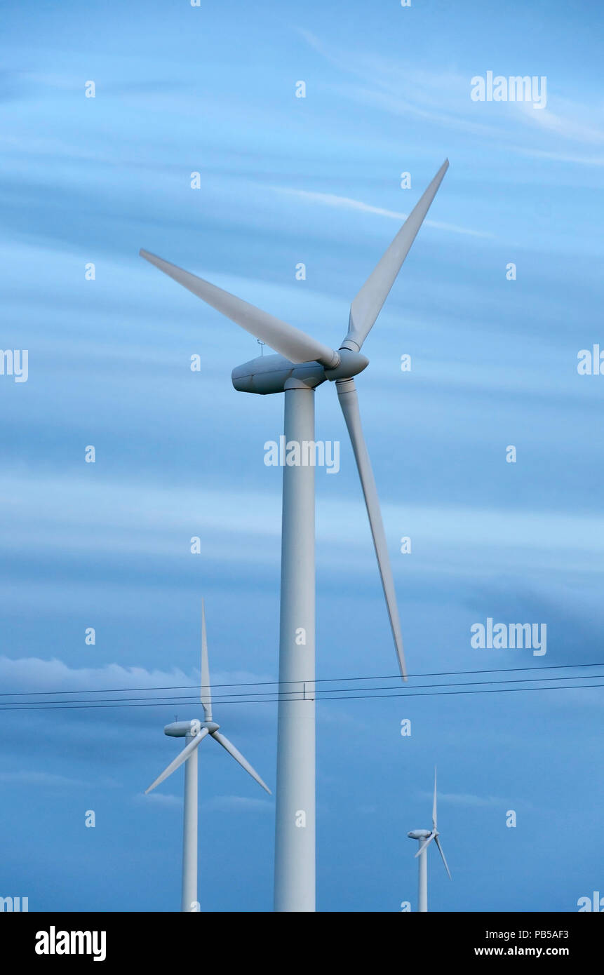 Las turbinas eólicas antes de cielo azul Foto de stock