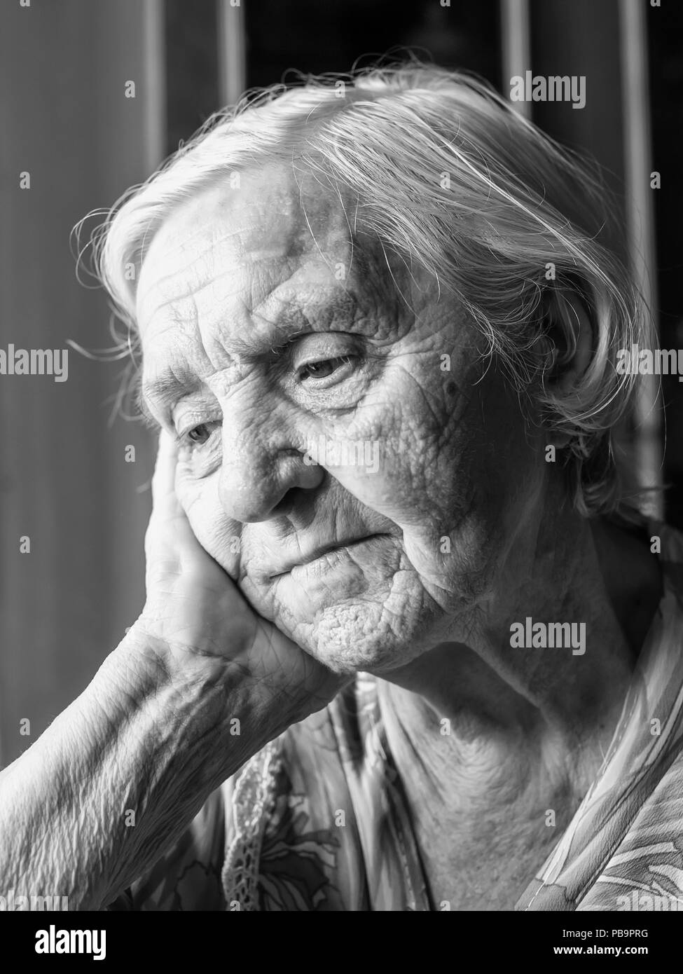 Bastante vieja abuela sentada sola pensando lindo Foto de stock
