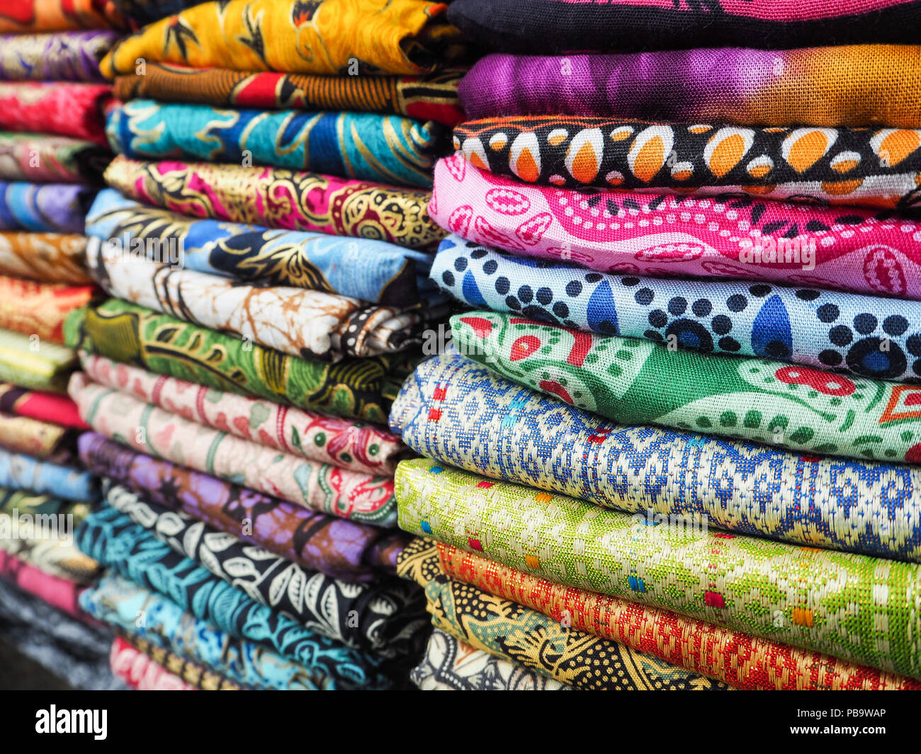 Montones de bufandas con colores brillantes en una tienda en Indonesia Fotografía de stock - Alamy