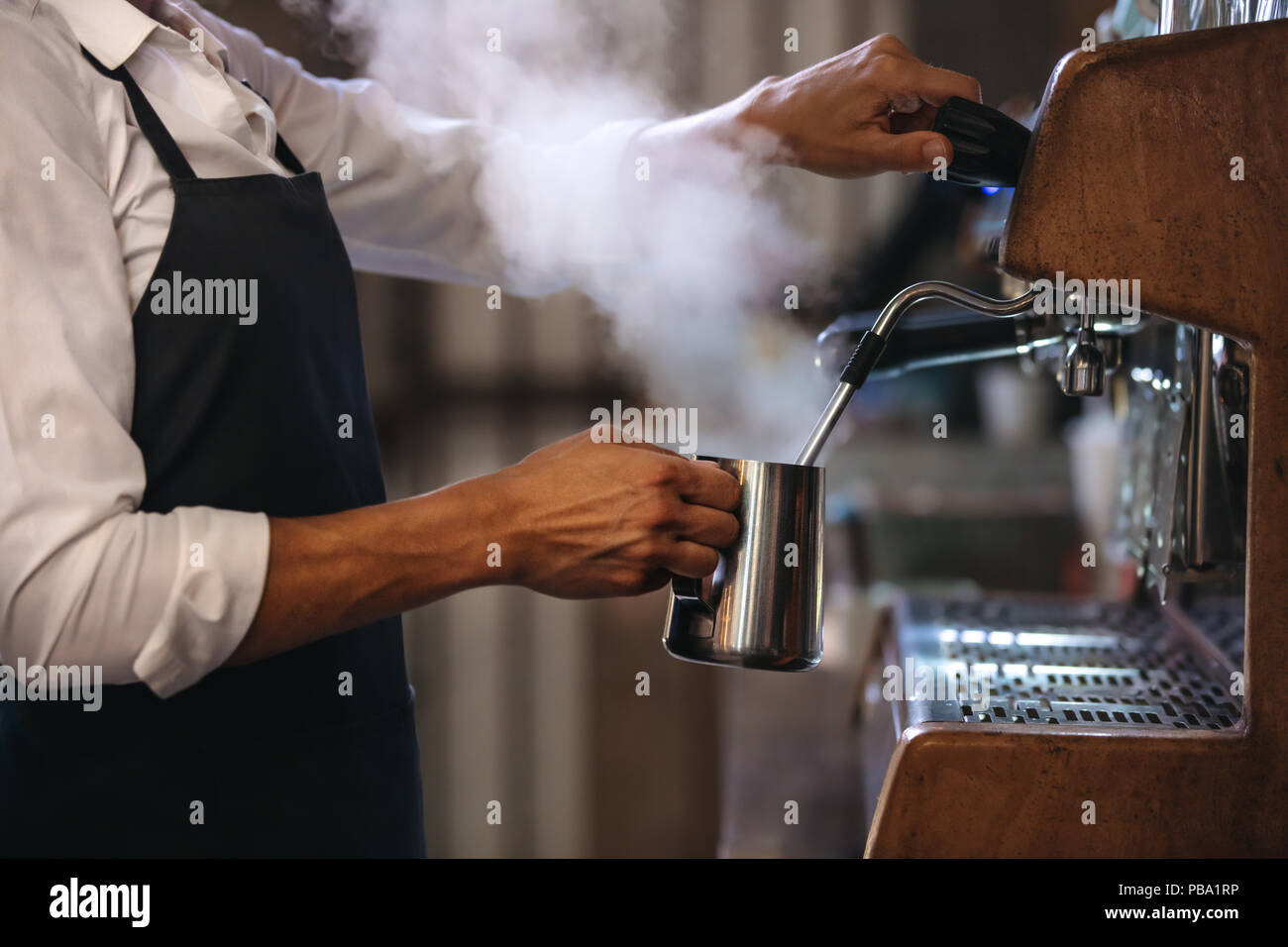Cafetería trabajador preparar café en vapor cafetera espresso. Captura  recortada del hombre que trabajaba en la cafetería. El uso de un delantal  Fotografía de stock - Alamy