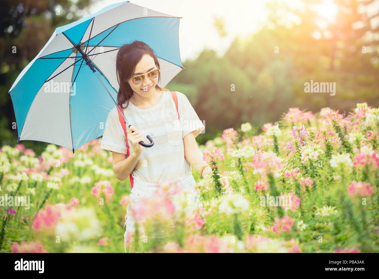 Hermosa teen pasear por el campo de flores green park piscina con sombrilla  en buen día soleado Fotografía de stock - Alamy