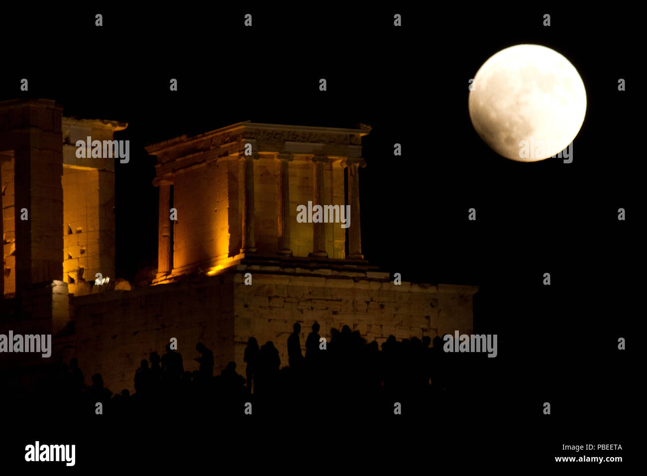 Atenas, Grecia. El 27 de julio, 2018. La luna llena se eleva sobre el  antiguo Templo de Atenea Nike en la Acrópolis, el eclipse lunar total el  viernes cuando el sol, la