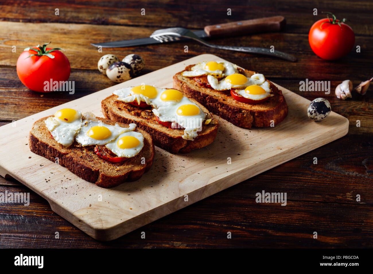 Pinchos con huevos de codorniz frito sobre placa de corte Foto de stock