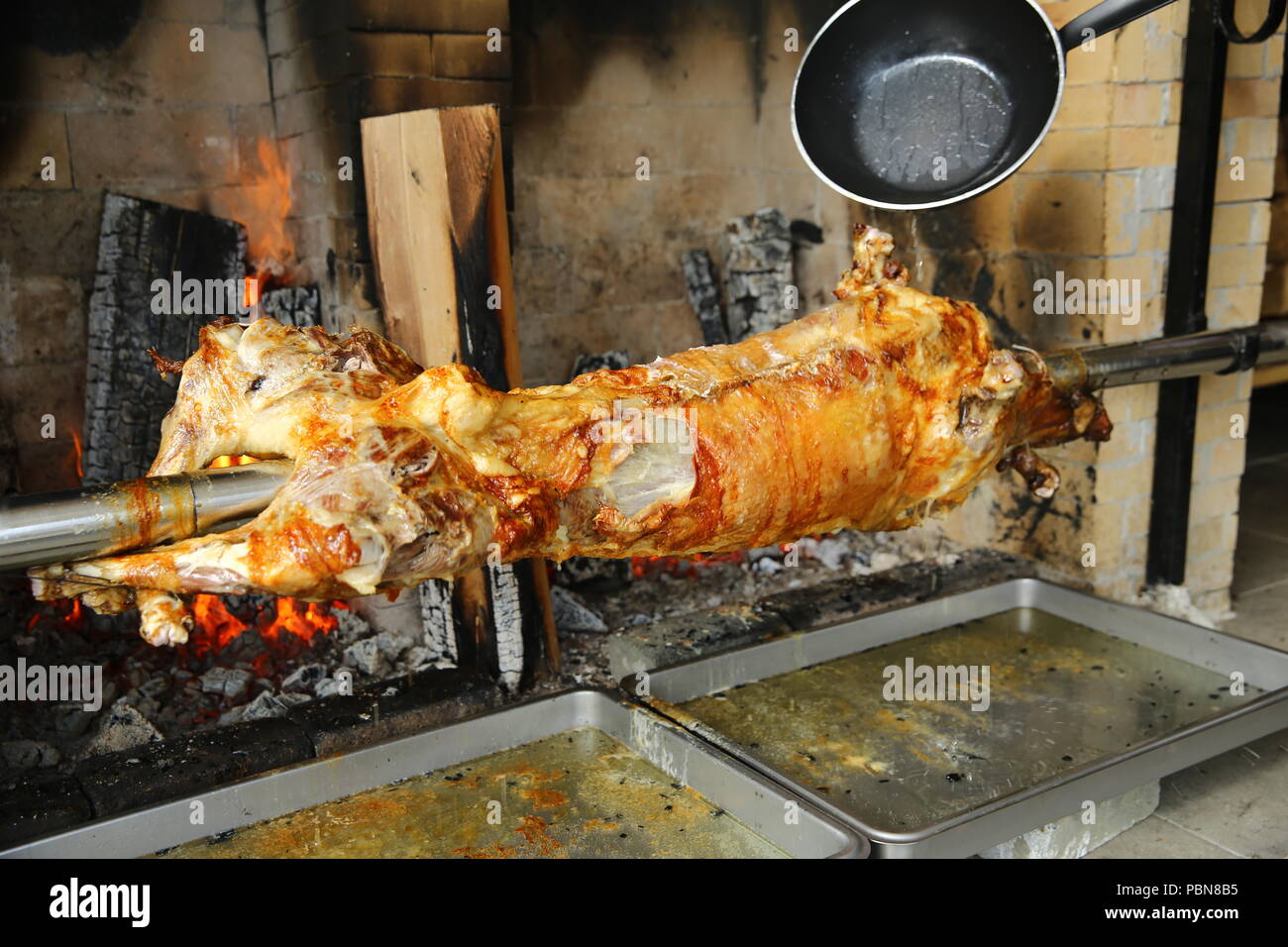 Cordero asado en un asador en el fuego Fotografía de stock - Alamy