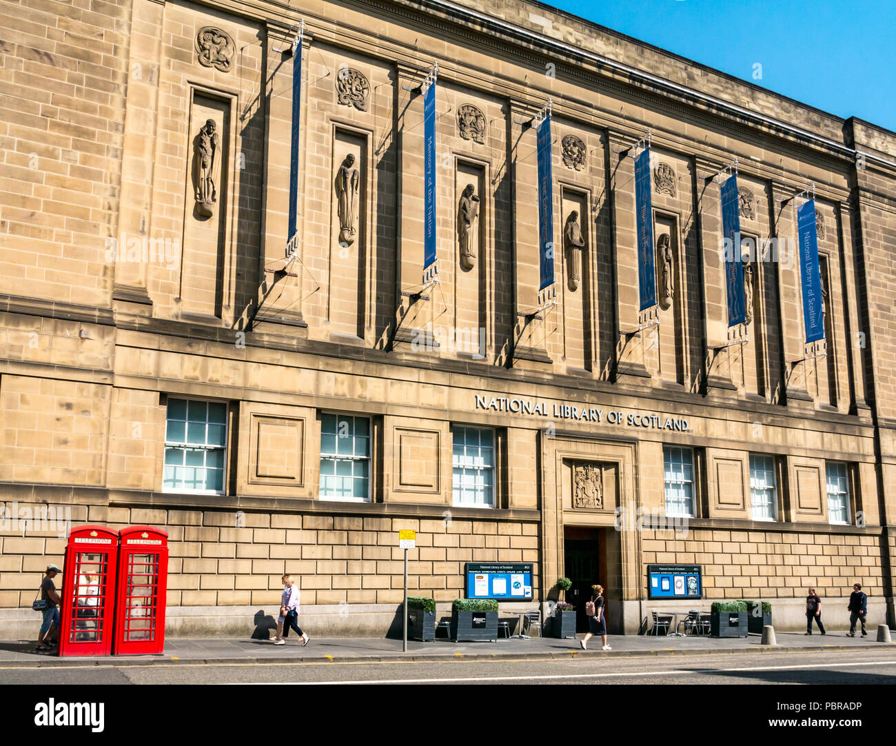 Estilo Art Deco de la Biblioteca Nacional de Escocia, el edificio de la biblioteca de depósito George IV bridge, Edimburgo, Escocia, Reino Unido, con cabinas de teléfono rojo Foto de stock
