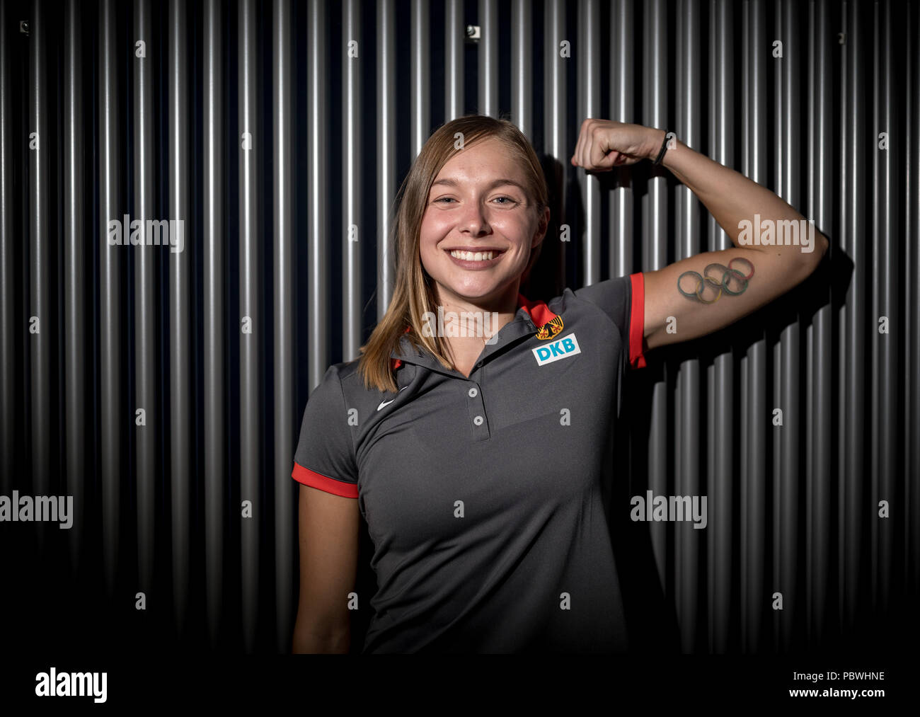 El 30 de julio de 2018, Alemania, Gruenheide, Kienbaum, fiesta de verano en el centro de capacitación, conferencia de prensa de la Asociación Alemana de Atletismo: Gina Lueckenkemper, velocista de 100 metros de la Asociación Alemana de Atletismo (DLV), muestra su tatuaje de los anillos olímpicos en sus bíceps. Foto: Michael Kappeler/dpa Foto de stock