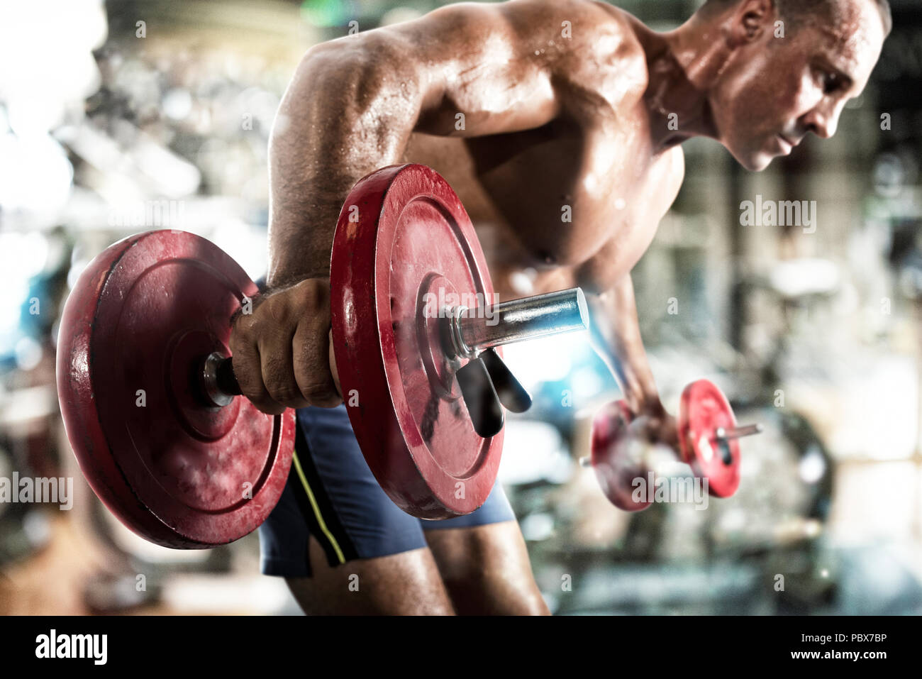 Athletic hombre bíceps entrenamiento en el gimnasio Foto de stock