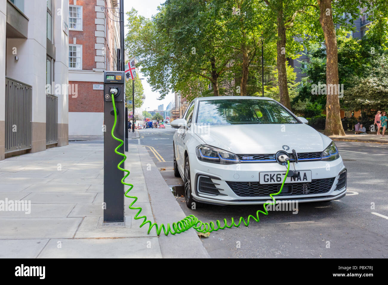 Londres, Inglaterra, Reino Unido; el 27 de julio de 2018; Blanco Volkswagen Golf GTE coche eléctrico híbrido enchufable cargando en una céntrica calle de Londres Foto de stock