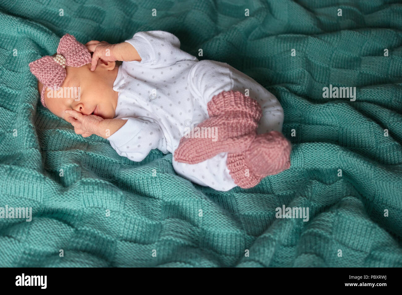 Niña recién nacido dormía en ropa de invierno. Woolean verde paño Fotografía de stock -