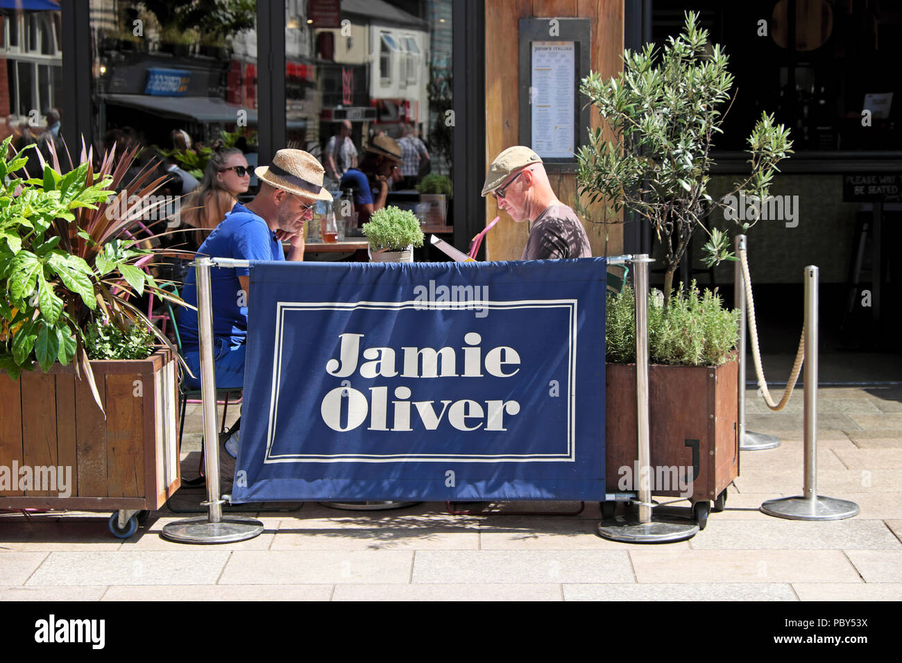 Jamie Oliver restaurante exterior con gente sentada comiendo fuera en las mesas en el centro de la ciudad de Cardiff Gales UK KATHY DEWITT Foto de stock