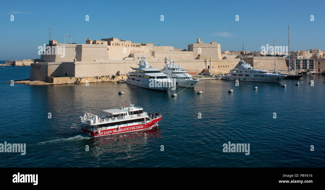 Barco pasando por el Fuerte de San Angelo, en el histórico Gran Puerto de Malta, Europa. Los viajes y el turismo internacionales. Foto de stock