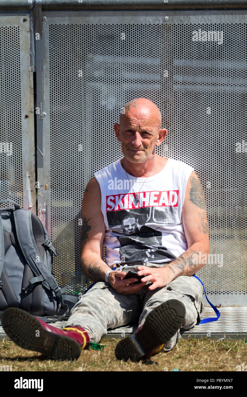 Un varón de mediana edad con la cabeza rapada, Botas Dr. Martens luciendo una camiseta con Skinhead escrito sobre ella. Foto de stock