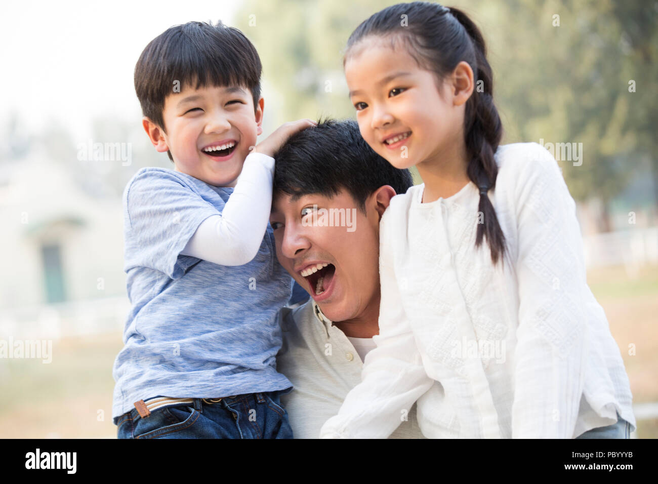 Joven alegre familia china jugar afuera Foto de stock