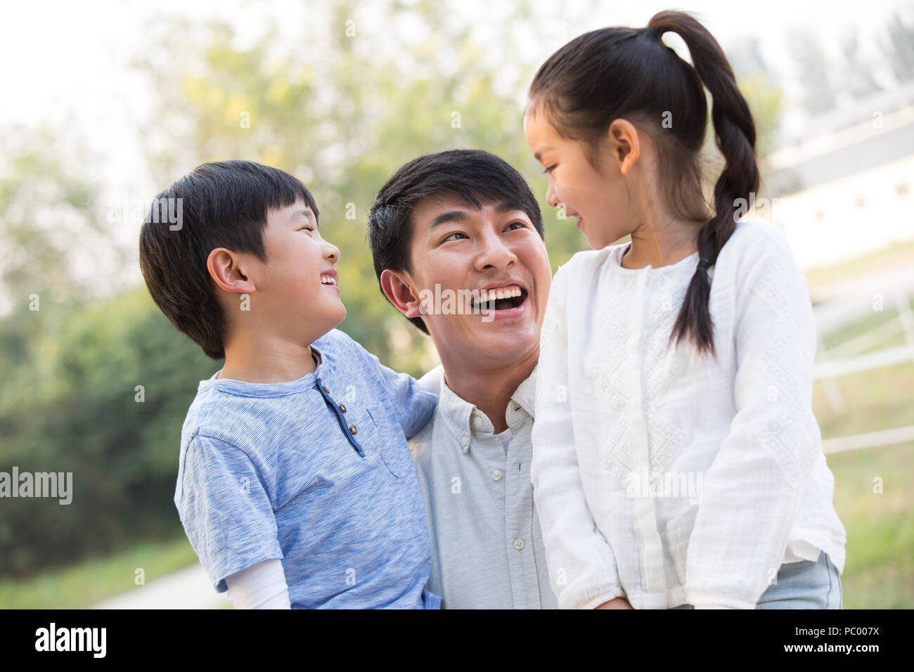 Joven alegre familia china jugar afuera Foto de stock