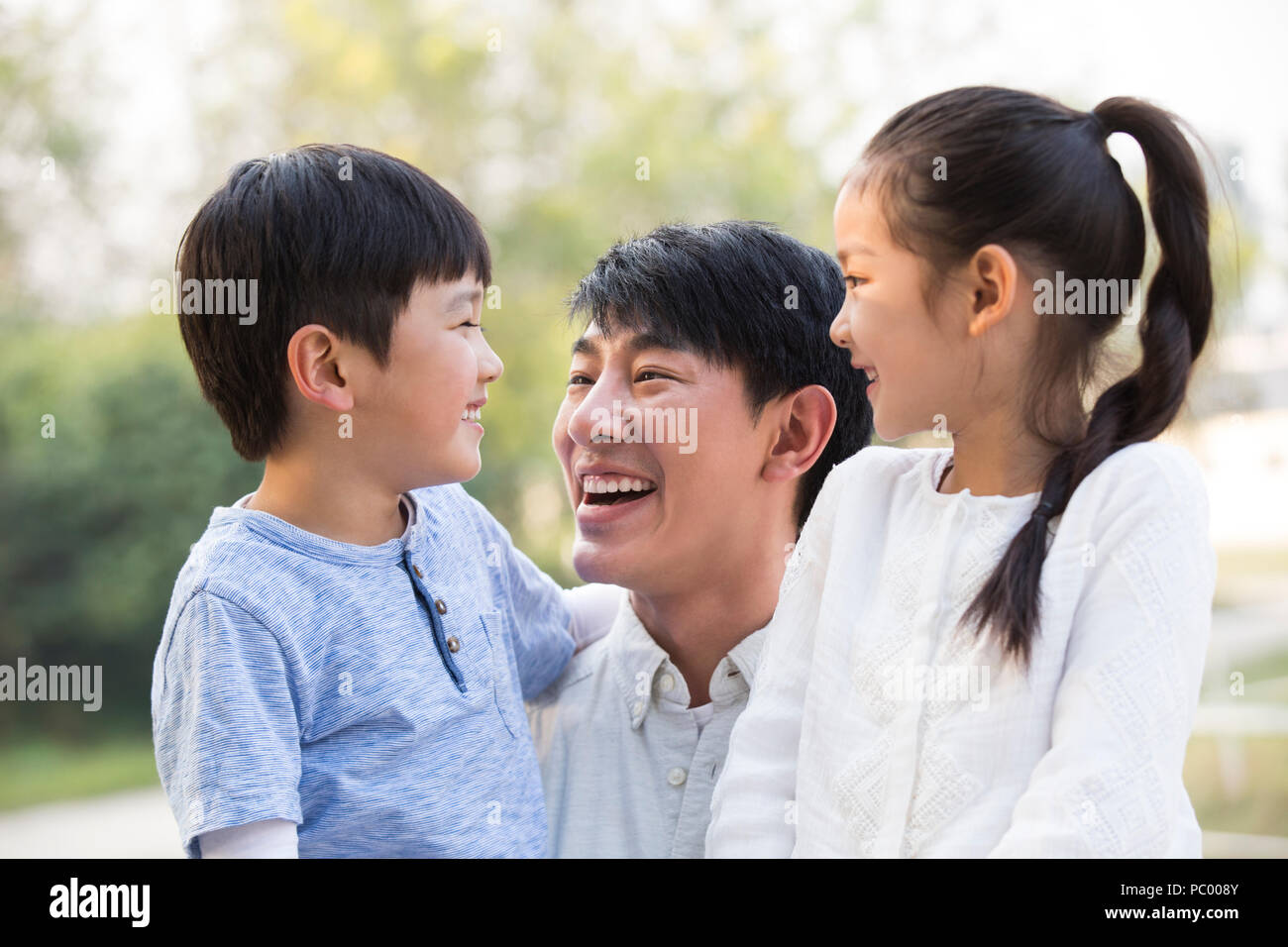 Joven alegre familia china jugar afuera Foto de stock