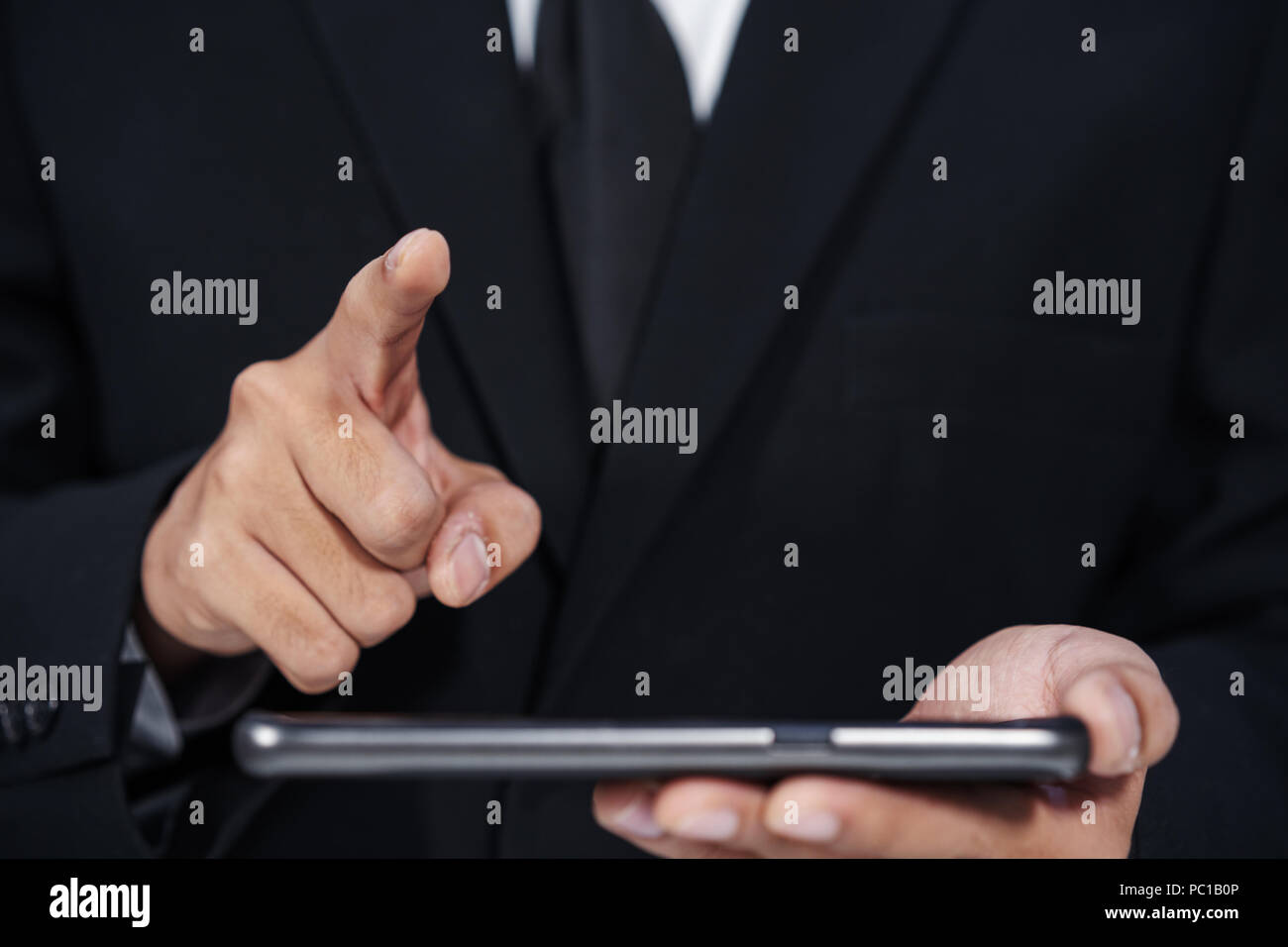 Hombre sujetando el smartphone empresarial y la mano para tocar la pantalla táctil virtual Foto de stock