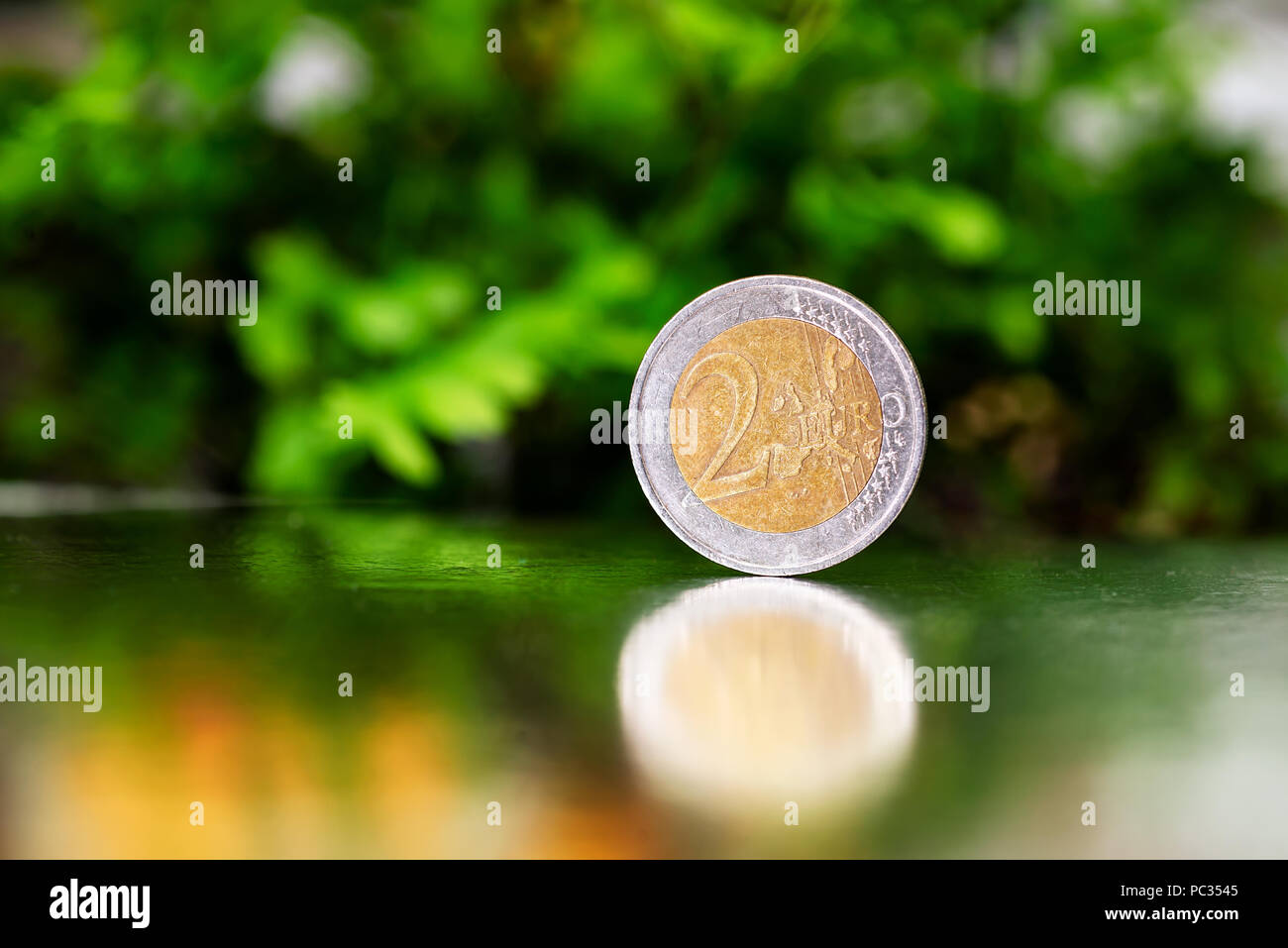 Dos monedas de euro closeup sobre fondo verde y plata Foto de stock