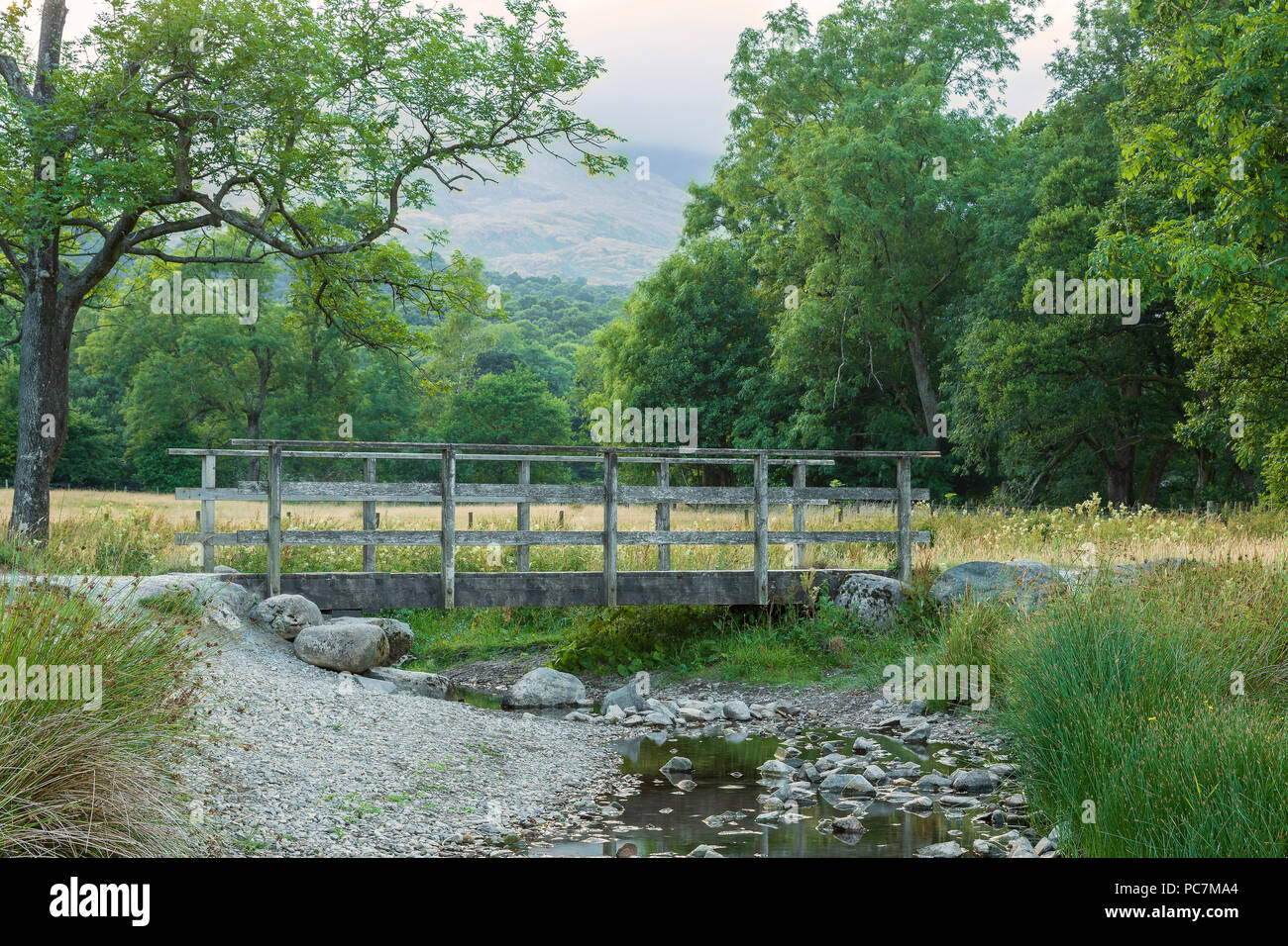 Una imagen de un viejo puente sobre una corriente superficial en el Lake District, Cumbria, Inglaterra, Reino Unido. Foto de stock