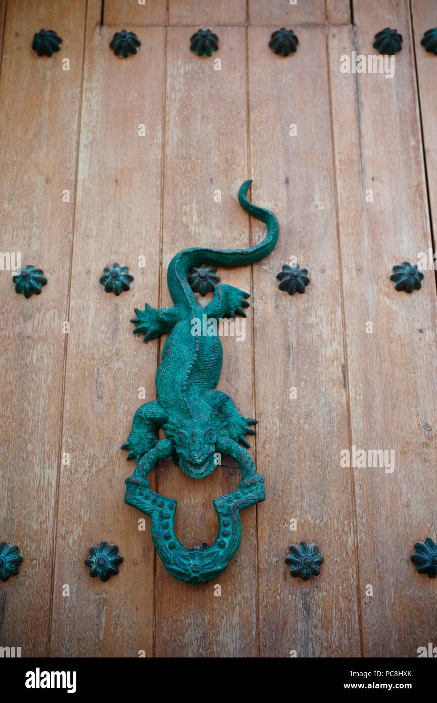 Puerta de hierro esculpido martinete en una antigua puerta de madera. Foto de stock