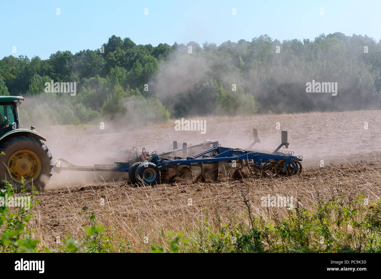 Tractor arando la tierra, máquinas agrícolas que trabajan en el campo Foto de stock