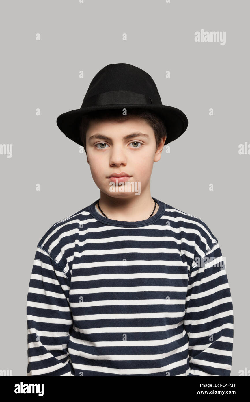 Dulce niño vistiendo la camiseta de rayas y un sombrero negro Fotografía de  stock - Alamy