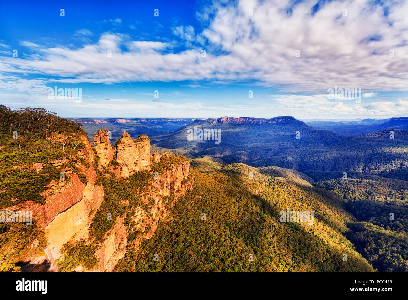Tres hermanas de rocas hito natural con Monte Soledad en una distancia más extenso valle visto desde Echo point lookout en Katoomba town - Azul Mou Foto de stock