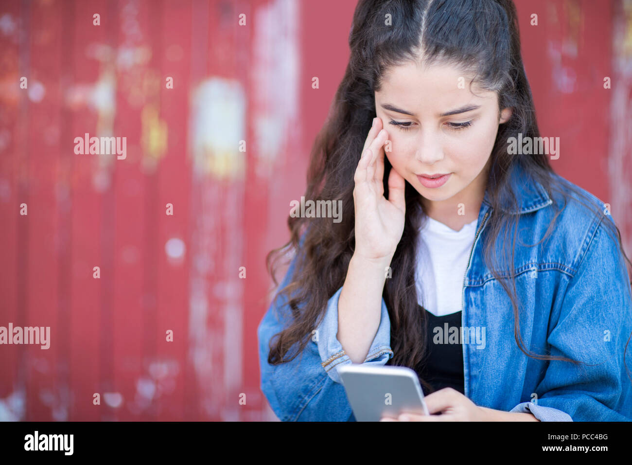 Adolescente víctima de intimidación por mensaje de texto al aire libre Foto de stock