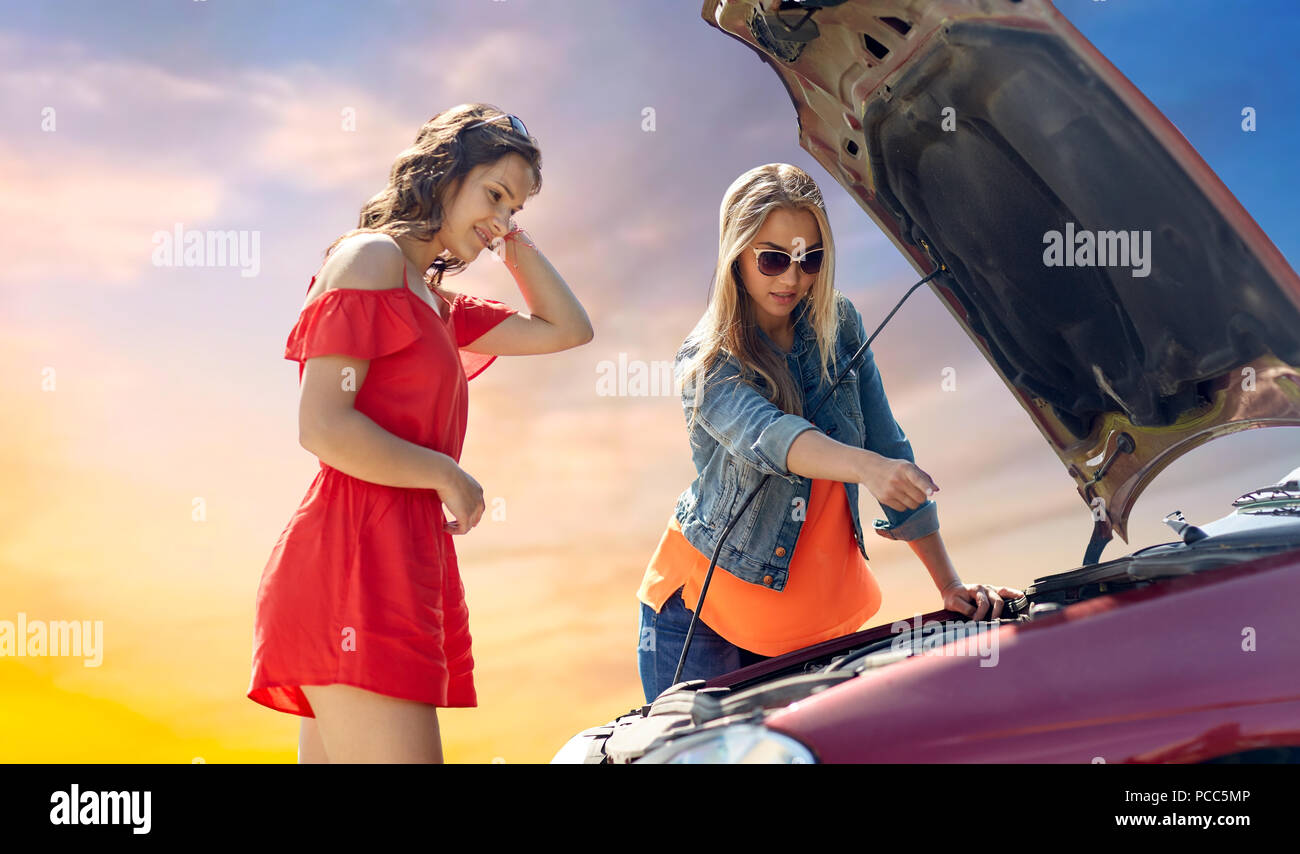 Las mujeres jóvenes con abrir el capó del coche roto Foto de stock