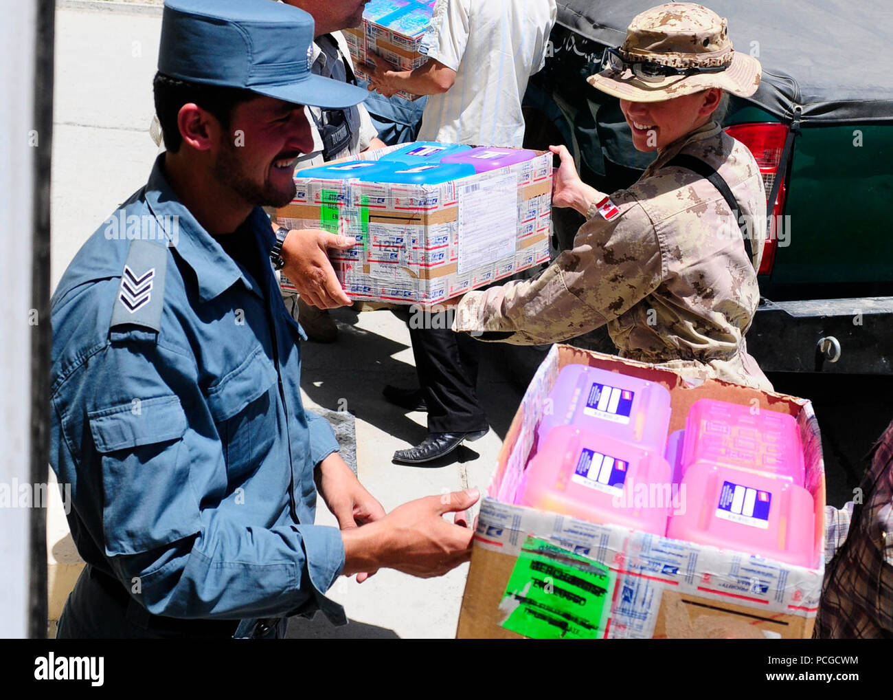 KABUL, Afganistán - Policía Nacional Afgana del orden civil y las fuerzas de la Coalición cargar cajas de suministros escolares en un camión para distribuirlos a una escuela cercana. Comando ANCOP Sgt. Gral. Abdul Wihad encabeza la donación de material escolar que tiene lugar una vez al mes Foto de stock