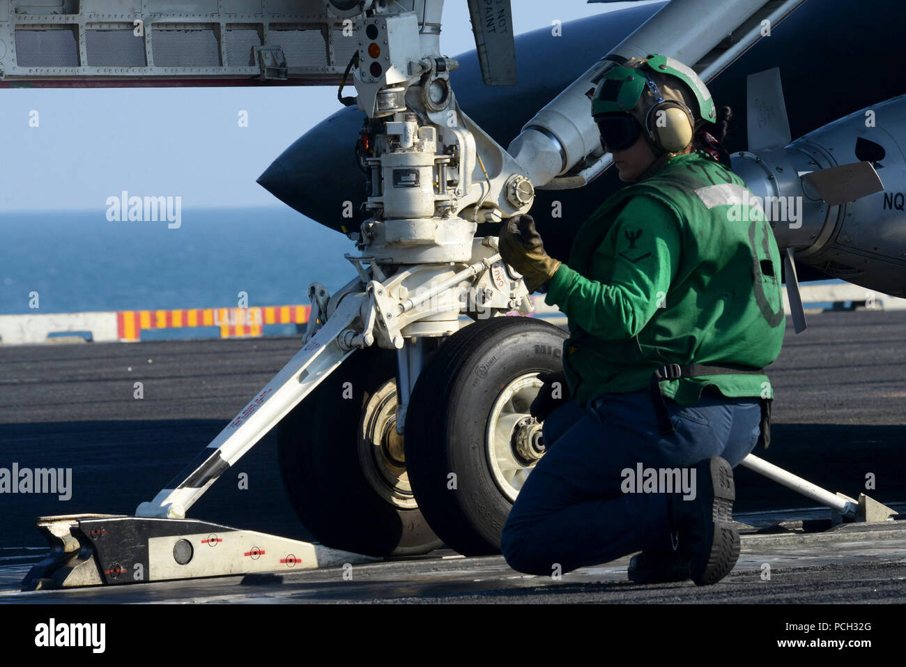 5ª Flota de EE.UU. ÁREA DE RESPONSABILIDAD (Dec. 29, 2012) la aviación Boatswain's Mate (equipos) de 3ª clase Mayra Sánchez señales para el movimiento de avance de un avión en la cubierta de vuelo a bordo del portaaviones USS John C. Stennis (CVN 74). John C. Stennis se implementa en la Quinta Flota de EE.UU. área de responsabilidad la realización de operaciones de seguridad marítima, el teatro y los esfuerzos de cooperación en materia de seguridad a las misiones de apoyo a la Operación Libertad Duradera. Foto de stock