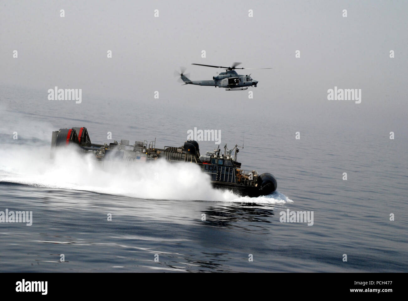 5ª Flota de EE.UU. Área de responsabilidad (de marzo. 29, 2013) un helicóptero UH-1Y Huey asignada al medio marino (HMM) Escuadrón 364 (REIN) se sitúa cerca de un desembarco, cojín de aire (LCAC) mientras participaba en un ejercicio con el dock buque anfibio de transporte USS Green Bay (LPD 20). Es parte de la Peleliu Amphibious Ready Group y embarcado, con elementos de la 15ª Unidad Expedicionaria de los Infantes de Marina (15 MEU), está desplegado en apoyo de operaciones de seguridad marítima y los esfuerzos de cooperación de seguridad de teatro en los EE.UU. 5ª Flota área de responsabilidad. Foto de stock