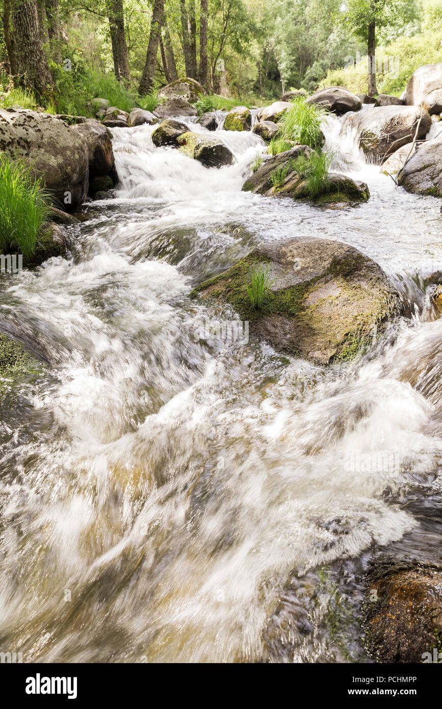 El agua corriendo por los rápidos de un río con piedras fotografiado a baja  velocidad para dar efecto de seda Fotografía de stock - Alamy