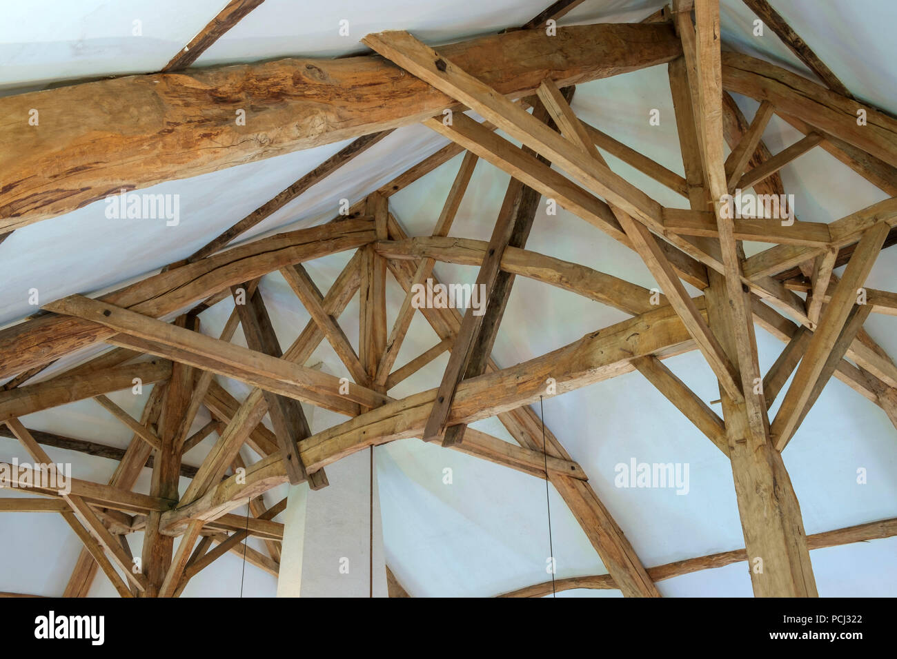 Mirando la masiva construcción de techo de madera interior restaurado en un francés antiguo Cortijo grande Foto de stock