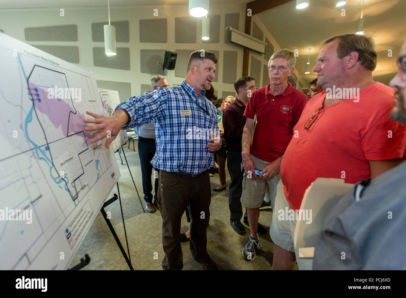 Pergamino, Michigan - Residentes de examinar un mapa que muestra la amplitud de las propuestas de acción contaminación de agua potable con un funcionario de la Michigan salen Foto de stock