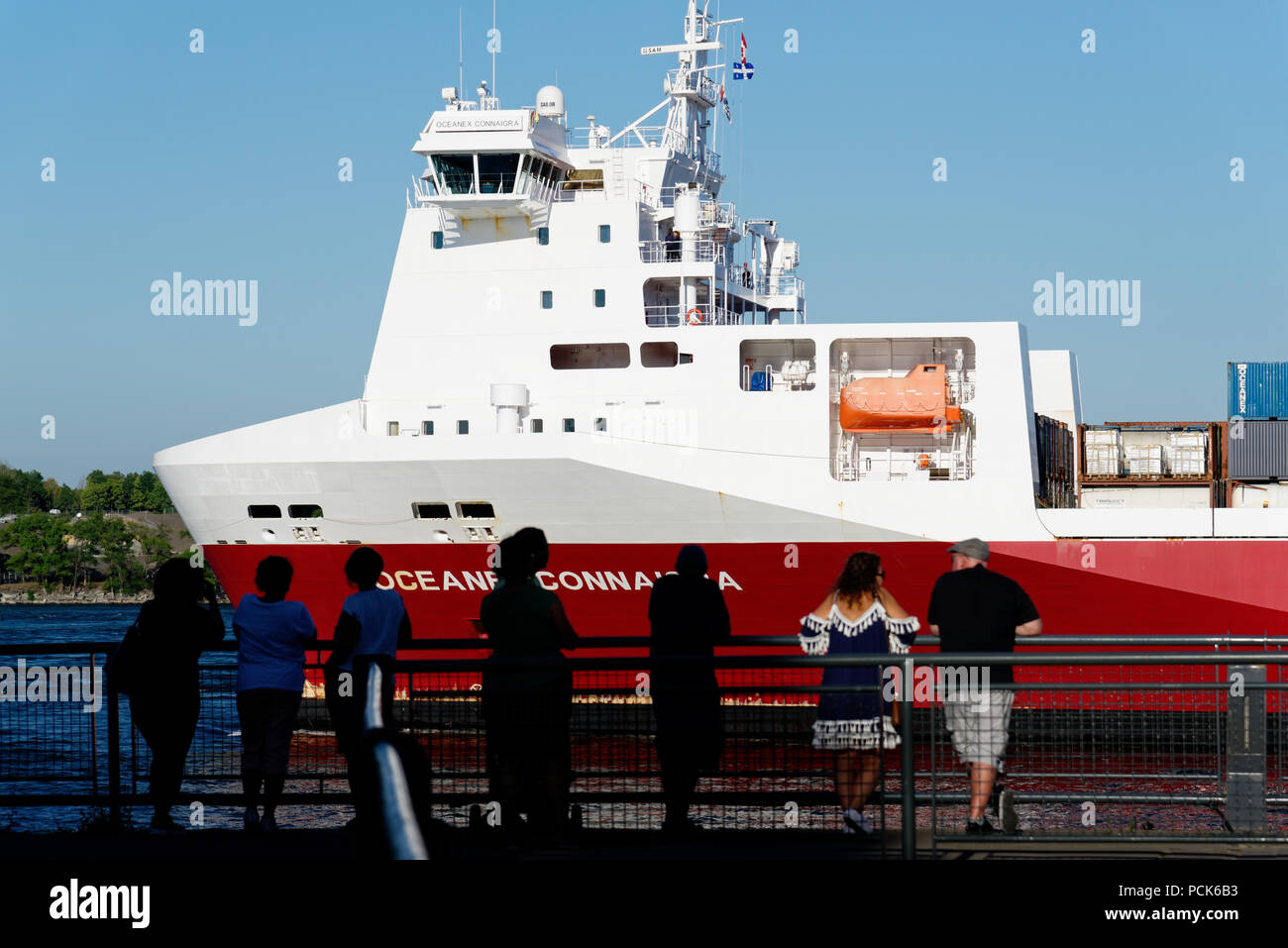 Viendo a la gente pasar de un buque de carga en el St Lawrence pasando ïle Bonsecours en el Viejo Puerto de Montreal Foto de stock